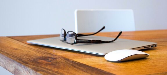 Laptop mit Brille auf dem Tisch