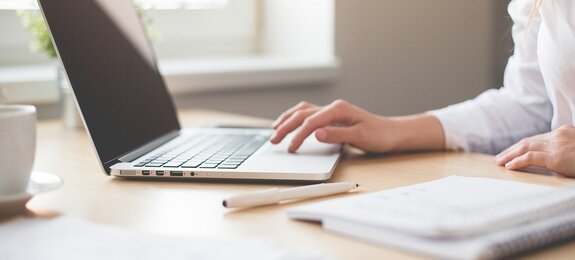 Notebook mit Frauenhand und Block