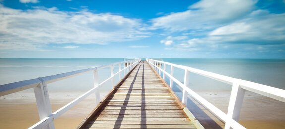 Holzsteg ins Meer führend