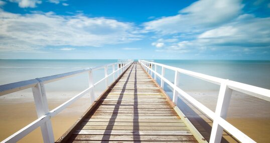 Holzsteg ins Meer führend