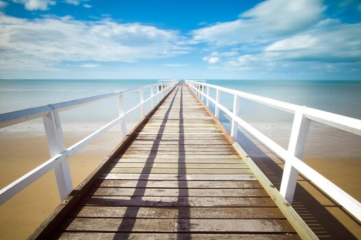 Holzsteg ins Meer führend